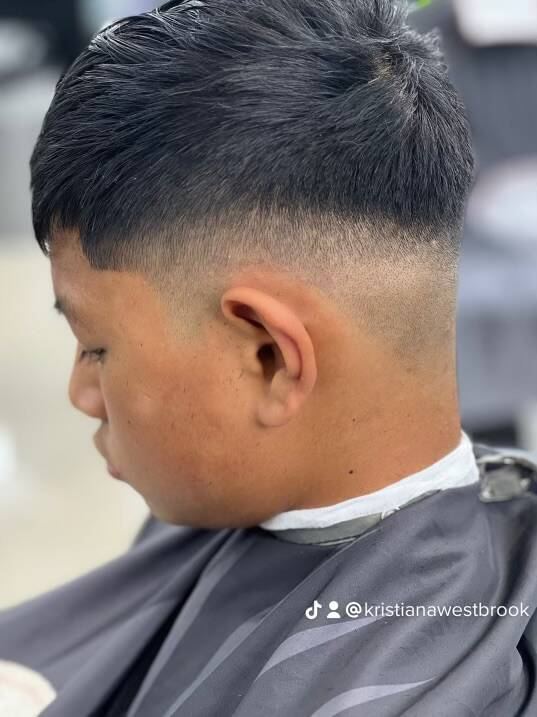 Dark textured top over a tight skin fade, seen from the side.