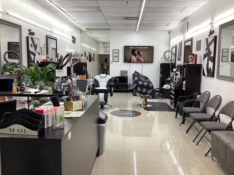 The main floor of Love More Cutz, with barber chairs, framed art and a waiting area.