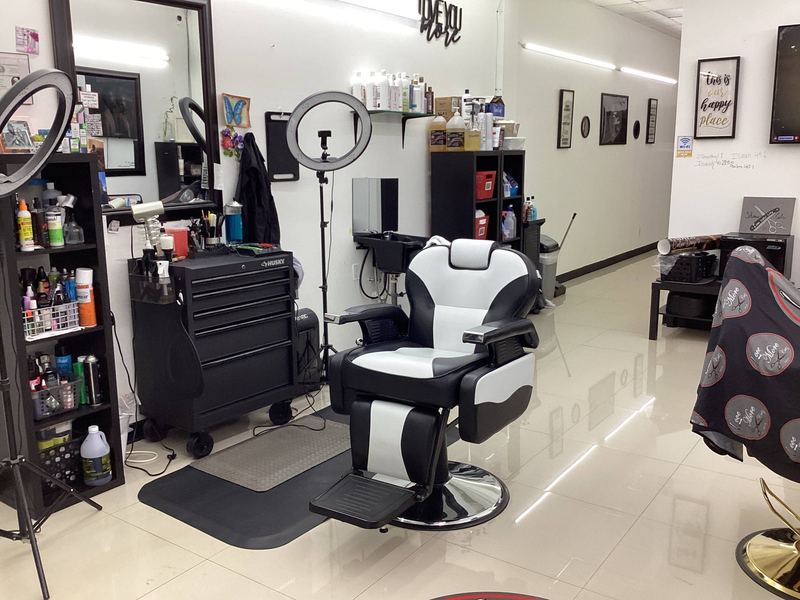 A barber station with a ring light, mirror and tools laid out ready.