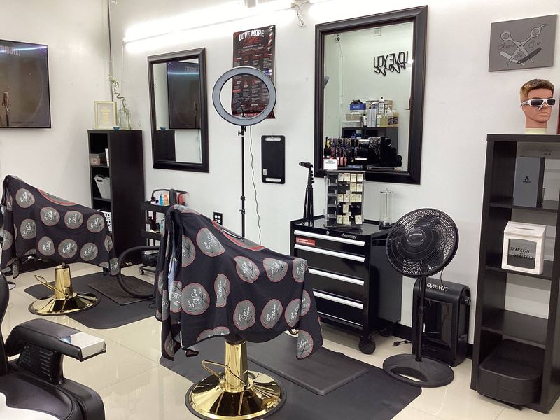 Two barber stations side by side with mirrors and printed chair covers.